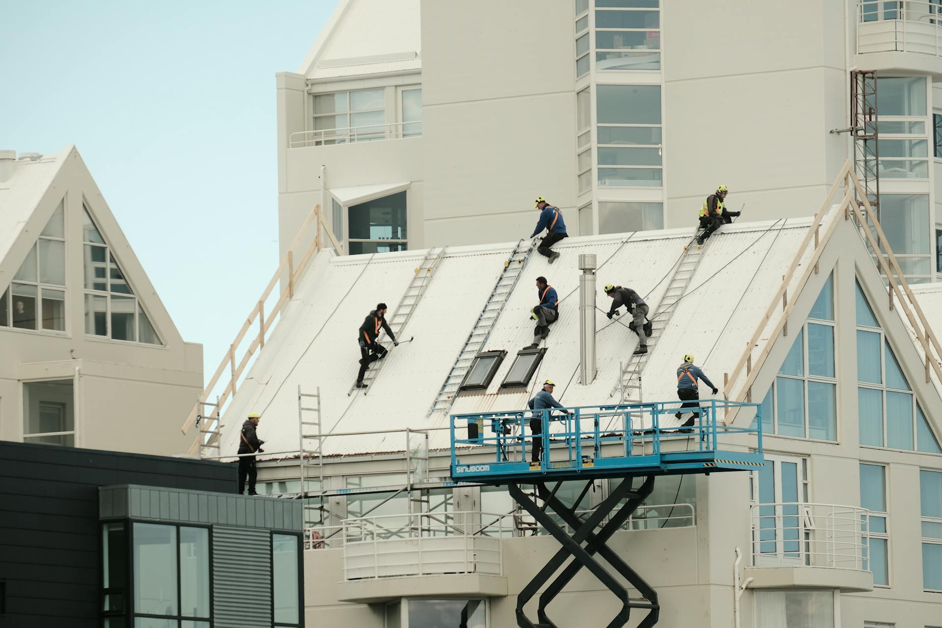Roofing contractors spreading roof coating on a commercial roof in Atlanta